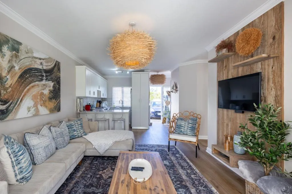 Open-plan lounge with sectional sofa looking through to the kitchen and entrance