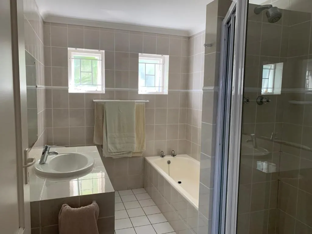 Bathroom with a built-in bath, separate shower, and frosted windows