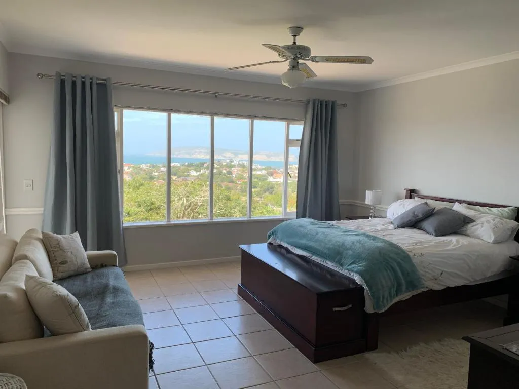 Bedroom with a picture window overlooking the bay, Robberg Peninsula, and rooftops below