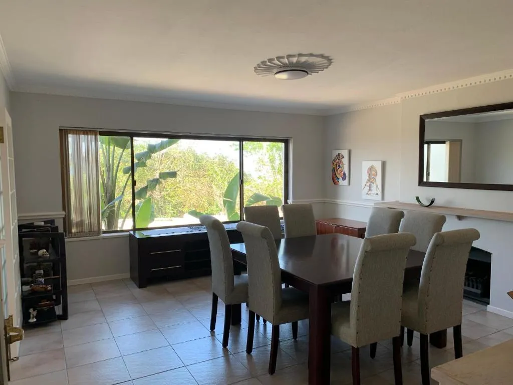 Dining room with a large table facing a garden window of banana plants
