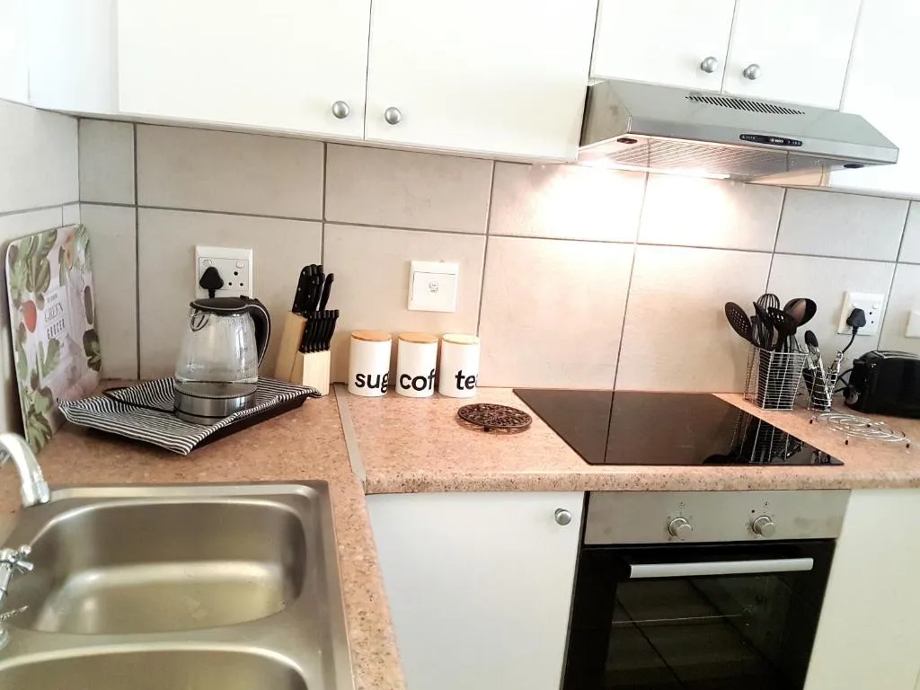Kitchen counter with hob, oven and tiled splashback in the fully equipped kitchen