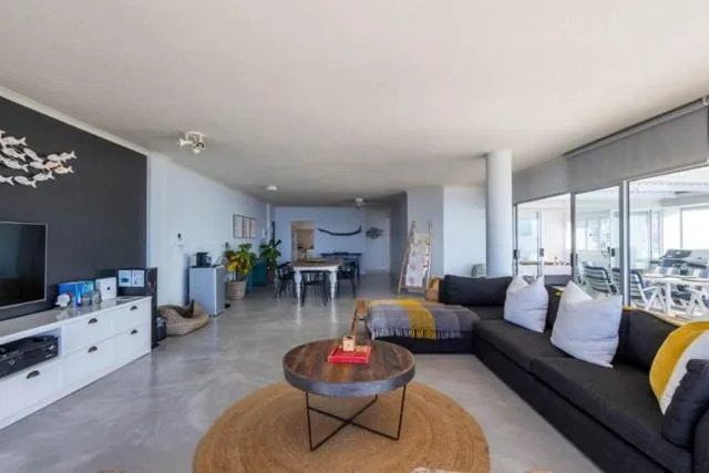 Living room with a dark feature wall, wall-mounted TV and a black sectional sofa