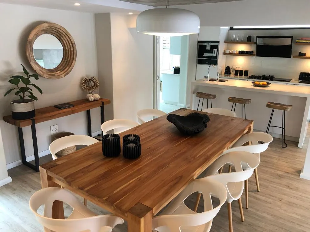 Open-plan kitchen and dining area with a live-edge oak table and built-in bar stools