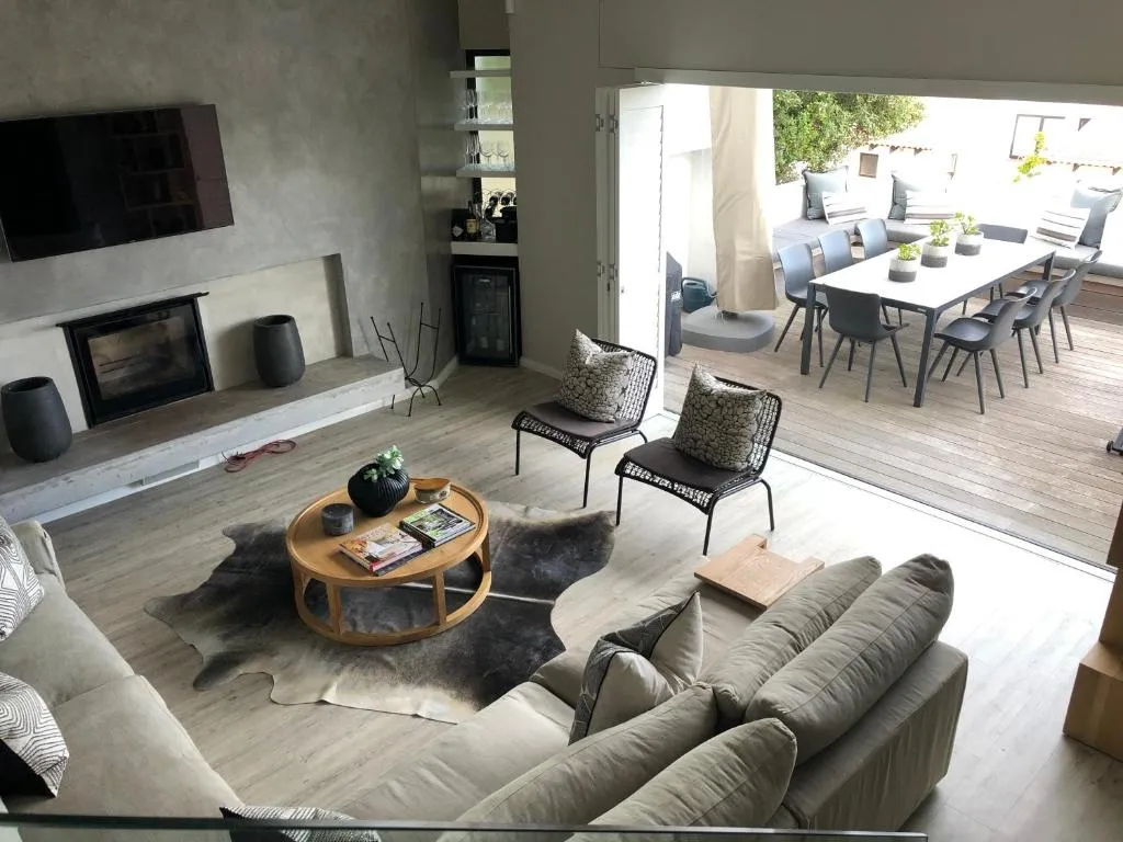 Sunken lounge with a built-in fireplace and glass doors opening onto the rooftop deck