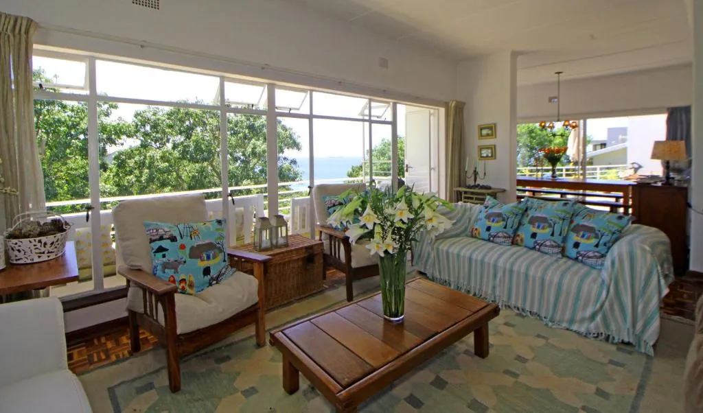 Open-plan living and dining area with sliding doors onto a balcony overlooking the sea