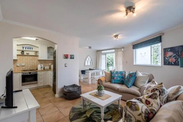 Open kitchen with an arched doorway, alongside a dining nook with French doors to the garden