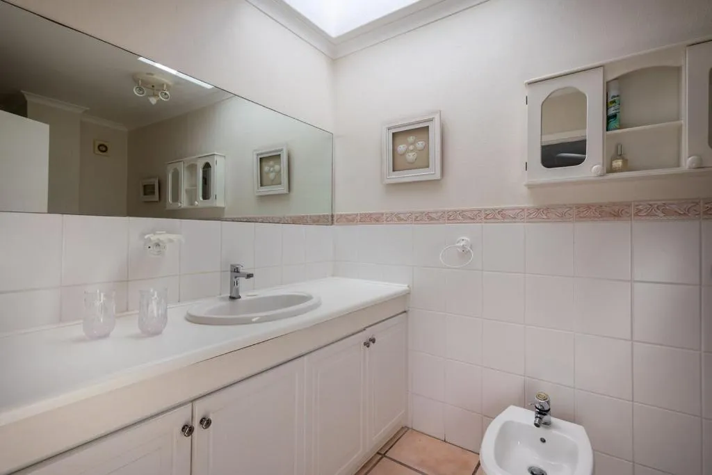 Bathroom with a double vanity, mirrored splashback and a corner bidet