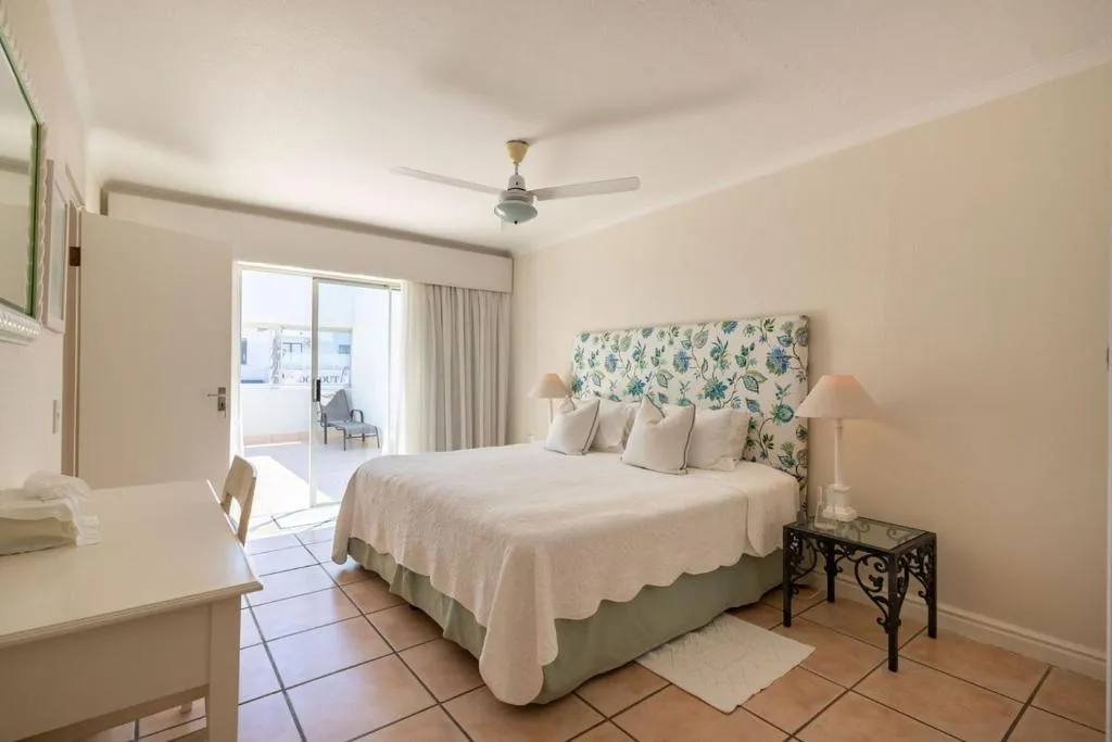 Bedroom with a floral headboard and sliding doors onto a private balcony