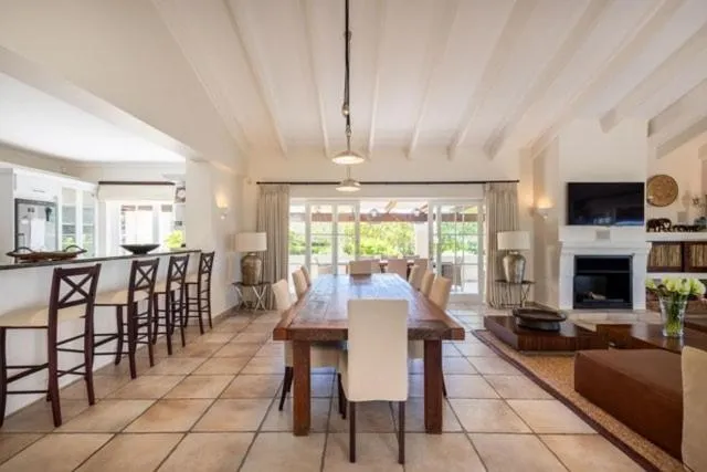 Open dining area with bar stools and a long table leading to the lounge