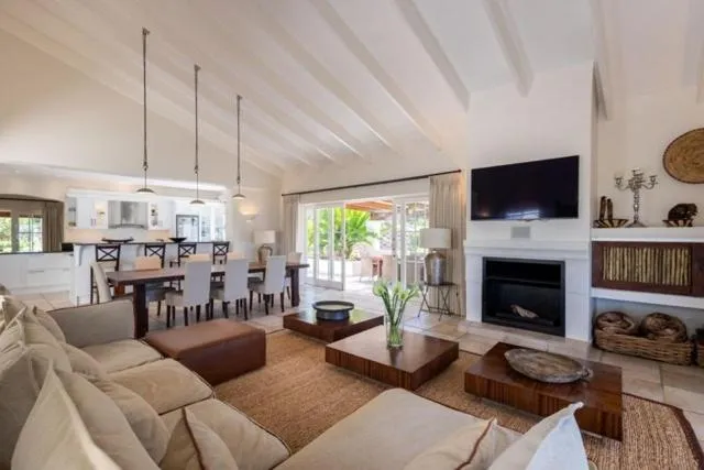 Vaulted-ceiling living room with sectional couch, fireplace, and wall-mounted TV