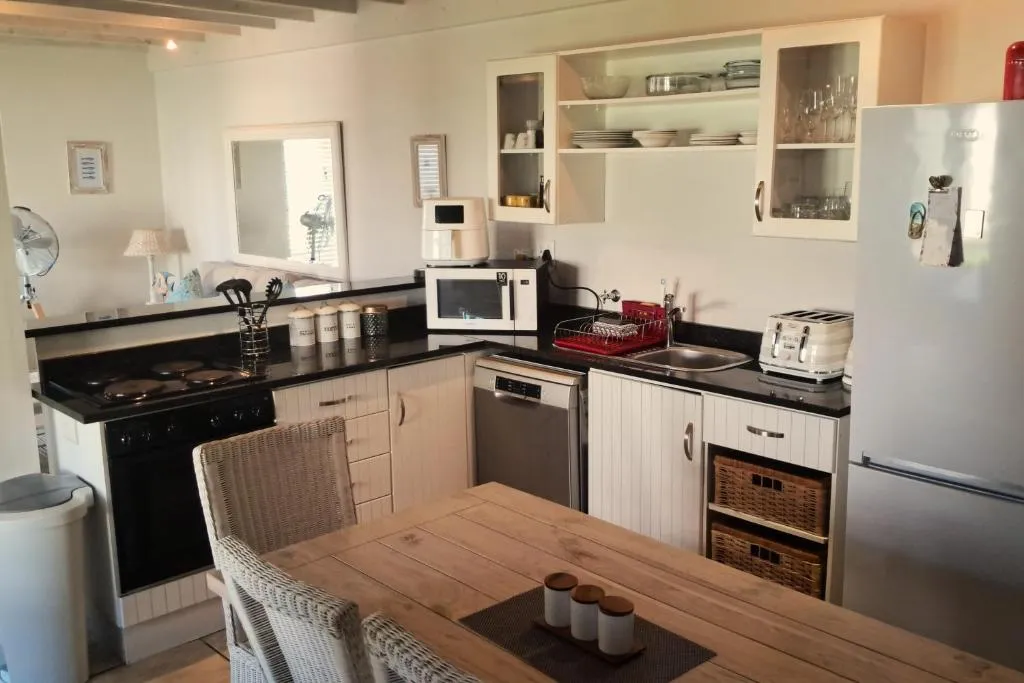 Kitchen with black countertops, cream cabinetry and a stainless steel fridge-freezer