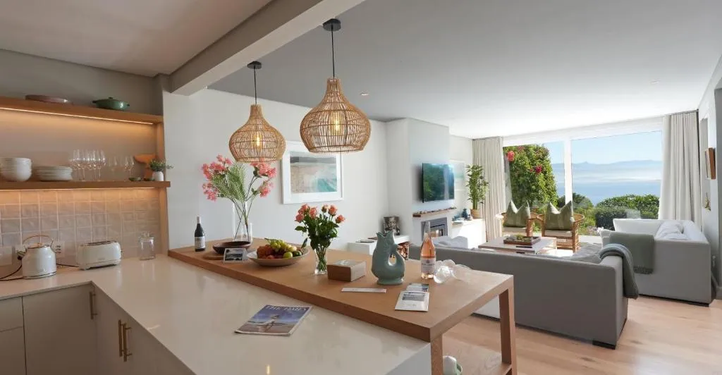 Kitchen counter with pendant lighting opening onto the lounge and its sea-facing view