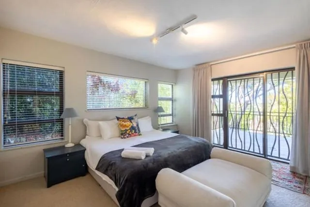 Bedroom with a queen bed, garden-view windows and glass doors opening onto a balcony