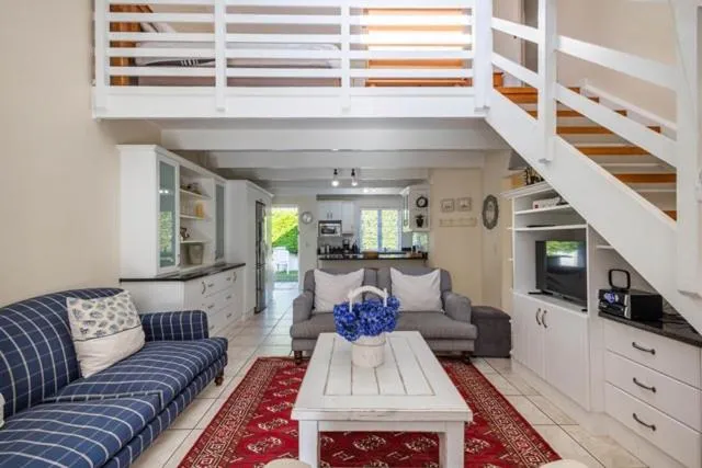 Double-volume living room with a mezzanine bedroom loft and staircase above