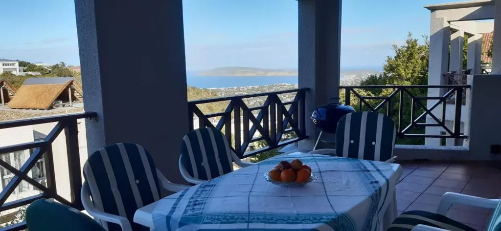 Open balcony with dining table looking out over the bay to the mountains beyond