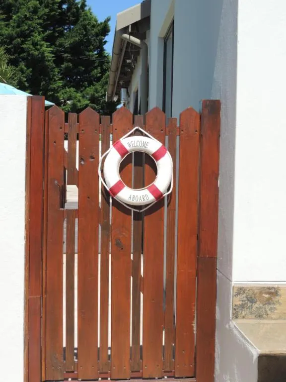 Wooden gate detail with a red-and-white 'Welcome Aboard' lifebuoy