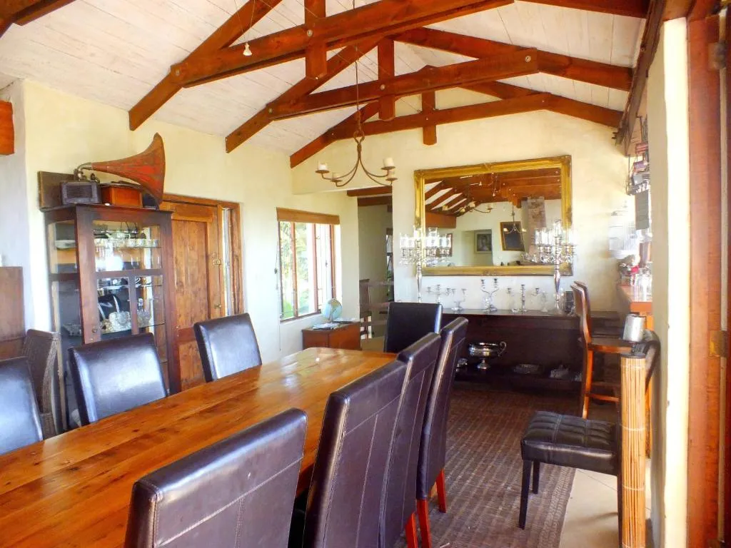 Dining room with exposed timber roof trusses, a long wooden table, and an antique gramophone