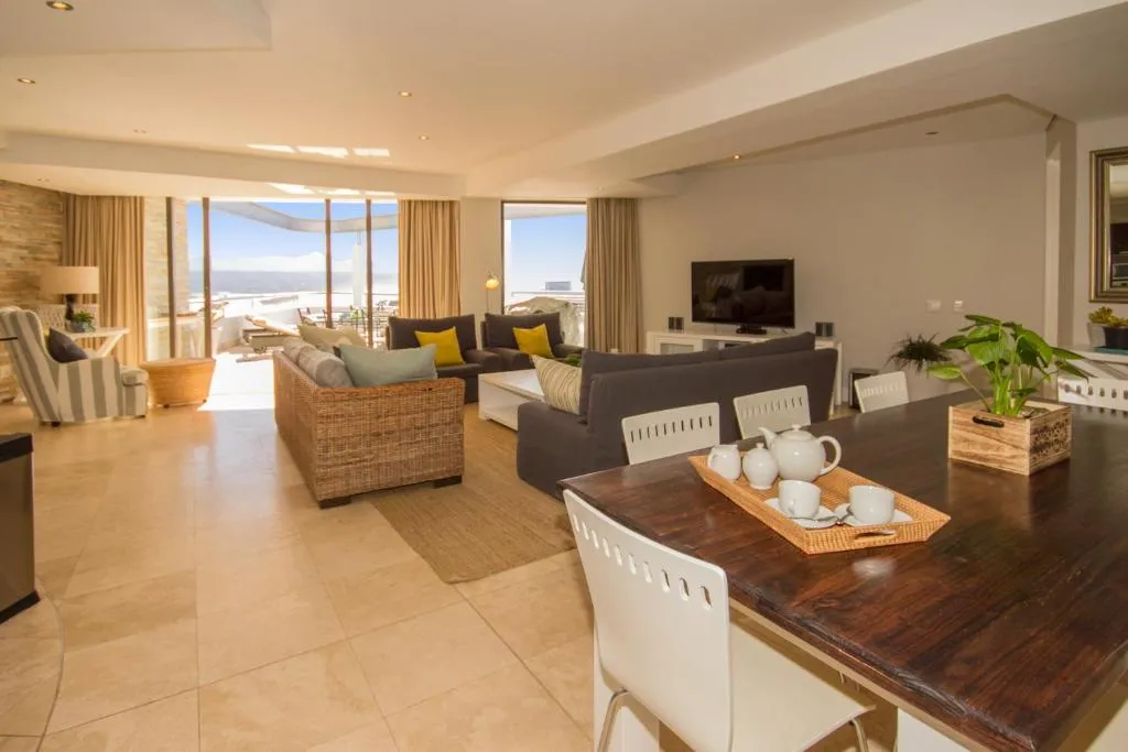 Open-plan lounge and dining area with sliding doors onto a terrace overlooking the lagoon