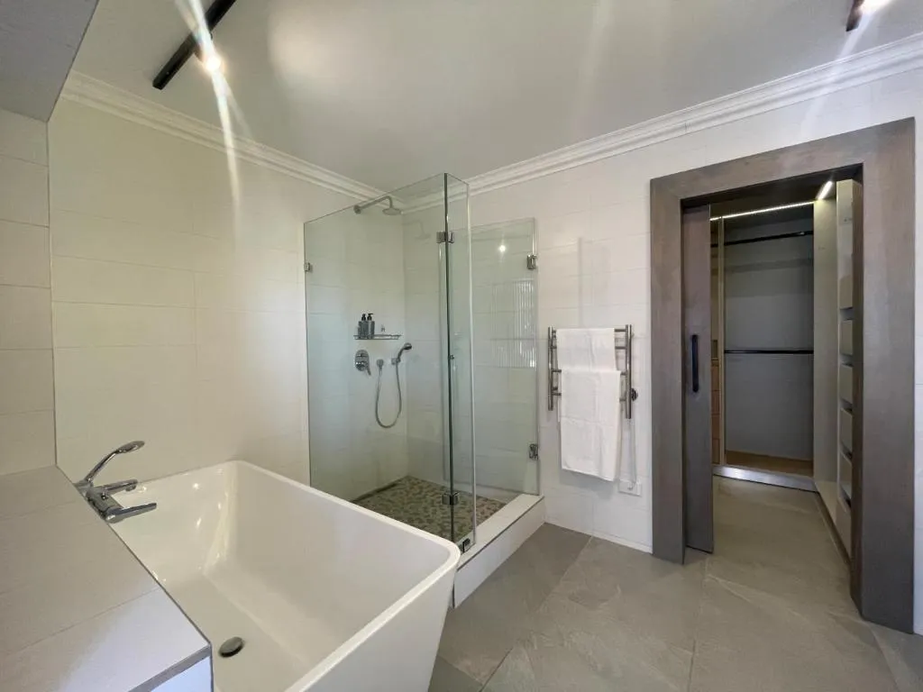 Bathroom with a freestanding tub, separate glass shower and a walk-in wardrobe leading off it