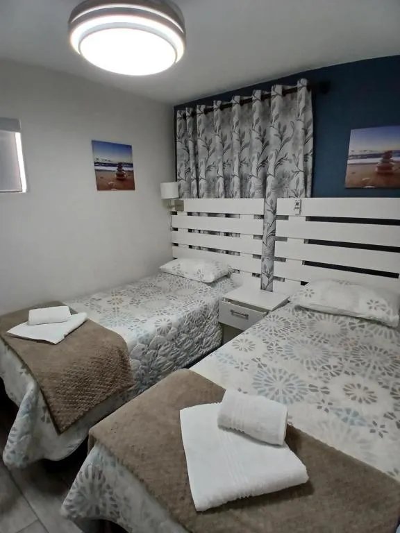Twin bedroom with beach photography prints either side of the headboard