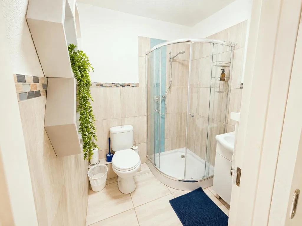 Bathroom with curved glass shower enclosure and a vanity basin