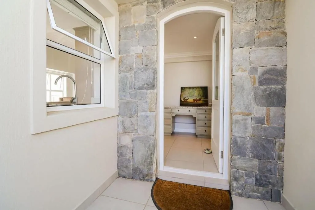 Stone-arched entrance passage leading to a small study with a writing desk