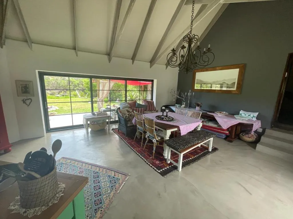 Dining room with vaulted wood-beam ceiling, wrought-iron chandelier and doors to the garden