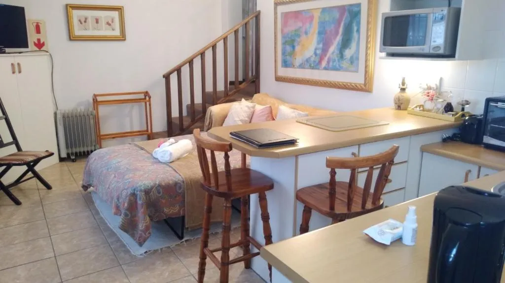Studio unit with a sofa bed, breakfast counter, and a staircase up to a sleeping loft