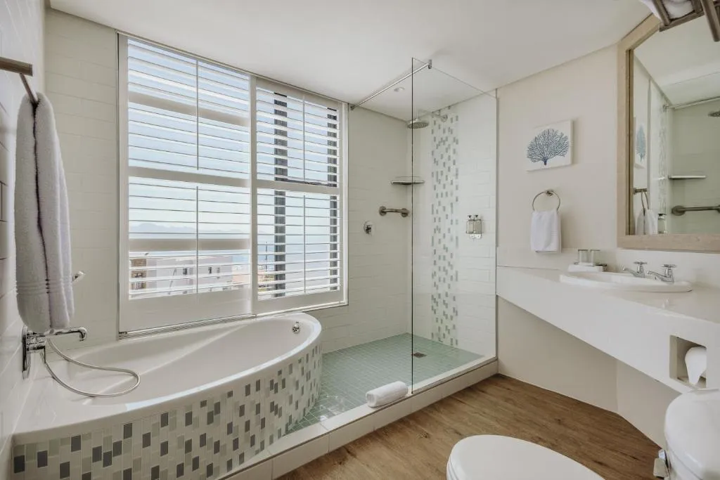 Bathroom with a freestanding tub, walk-in shower and a window looking toward the sea