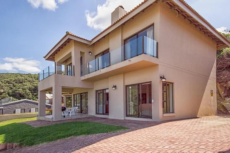 Rear elevation of the home with covered balconies and a paved courtyard