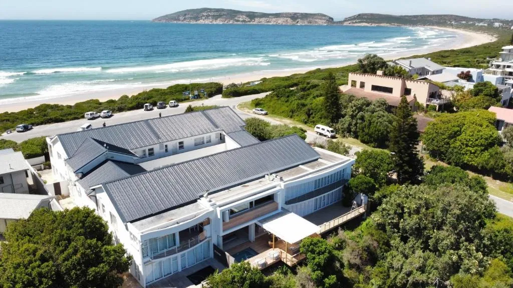 Aerial view of the beachfront apartment building beside the shoreline and headland