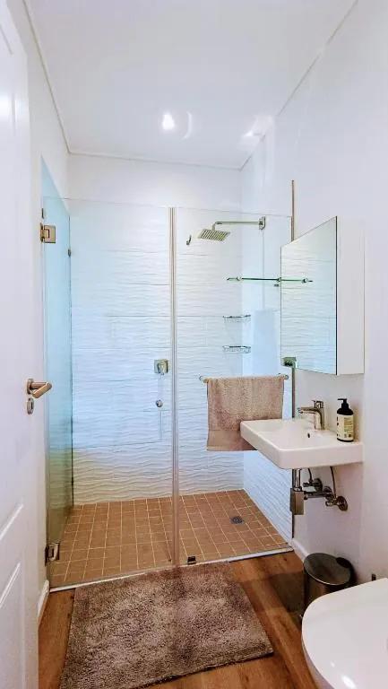 Bathroom with a glass-enclosed shower, mirrored cabinet and mounted towel rail