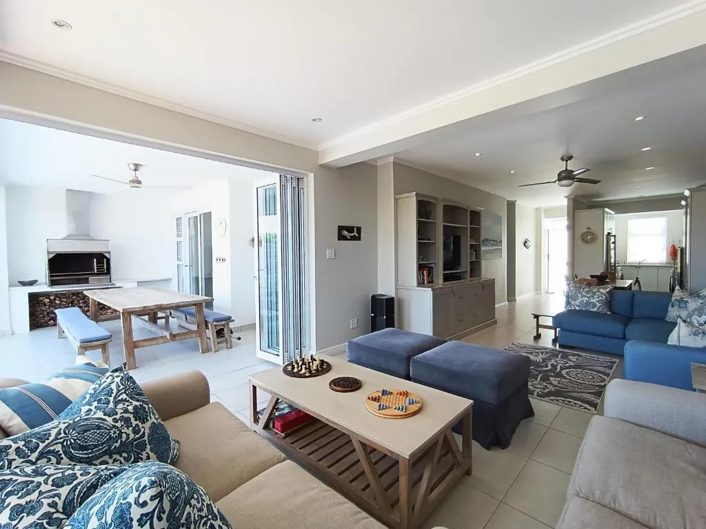 Open-plan living and dining area with a built-in braai and firewood store along one wall