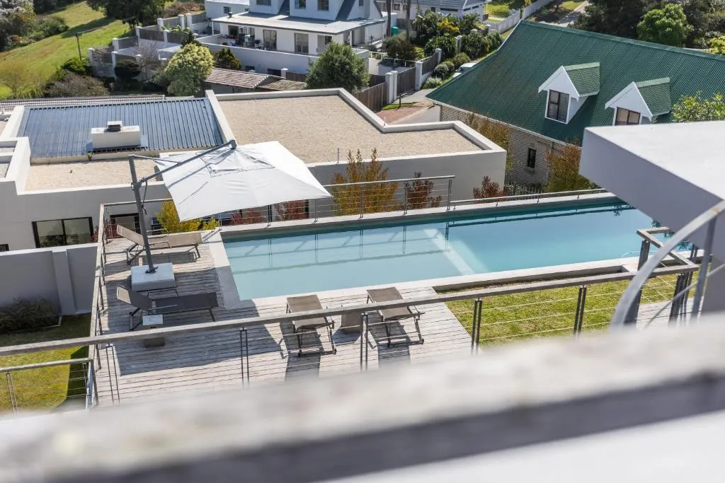 Aerial view of the rooftop lap pool with sun loungers, umbrella and wooden deck