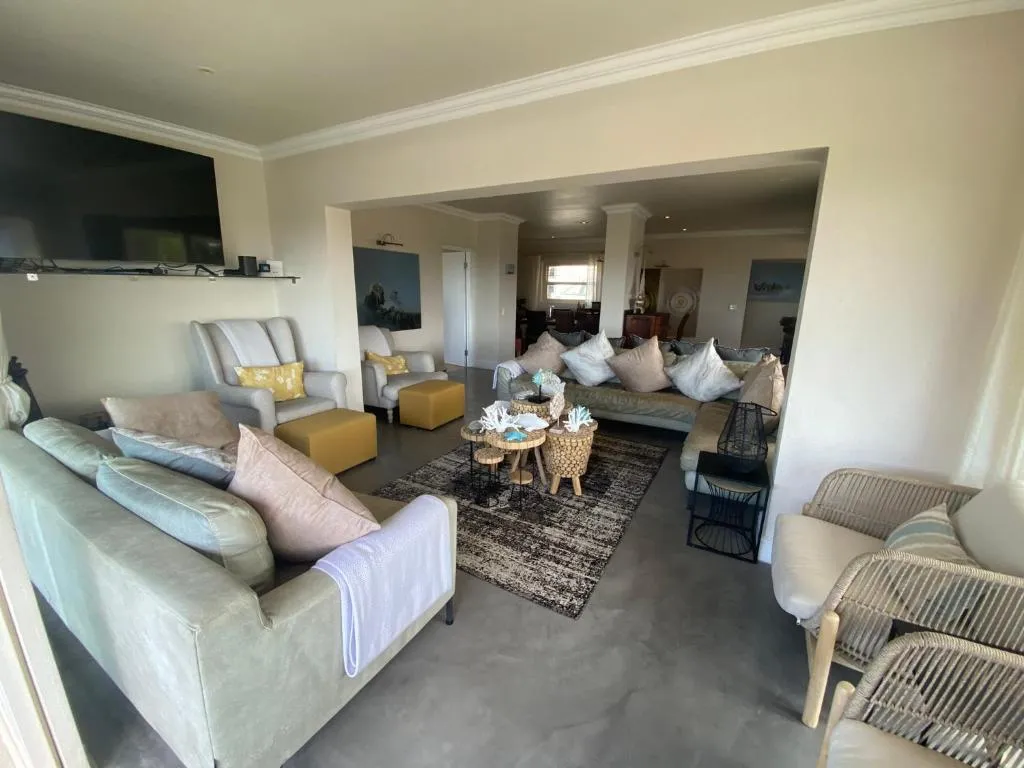 Open-plan living room with wall-mounted TV and beige upholstered seating