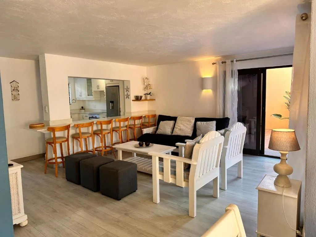 Open-plan living and kitchen with a breakfast bar seating six and sliding doors to a balcony