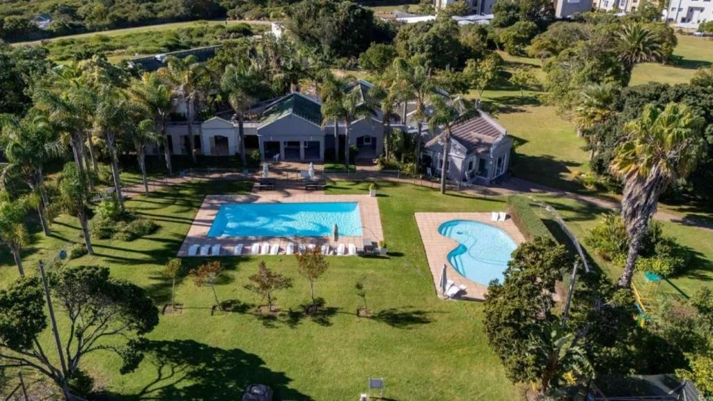 Aerial view of the estate clubhouse with two shared pools set in landscaped grounds