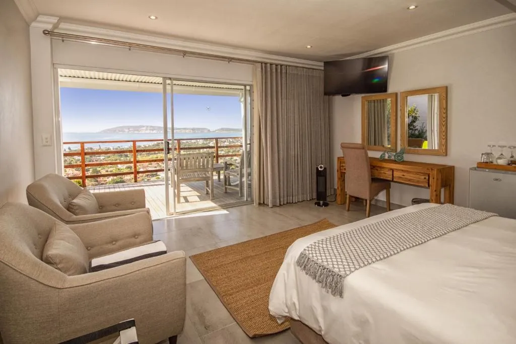 Bedroom opening onto a balcony with a wide view over the lagoon and bay
