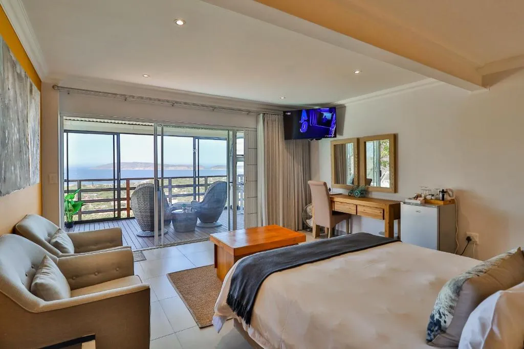Bedroom with a private balcony seating area overlooking the lagoon mouth and headland