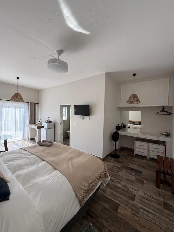 Bedroom with ceiling fan, vanity mirror and sliding door onto a balcony with white balustrade