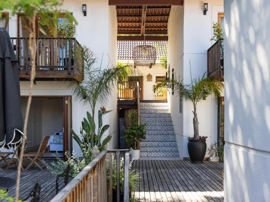 Courtyard with a patterned tiled staircase, timber balconies and potted palms