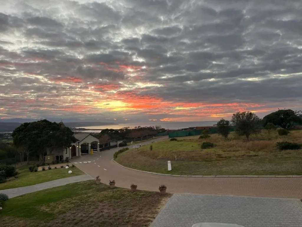 Sunset view down the estate access road past the gatehouse toward the sea in the distance