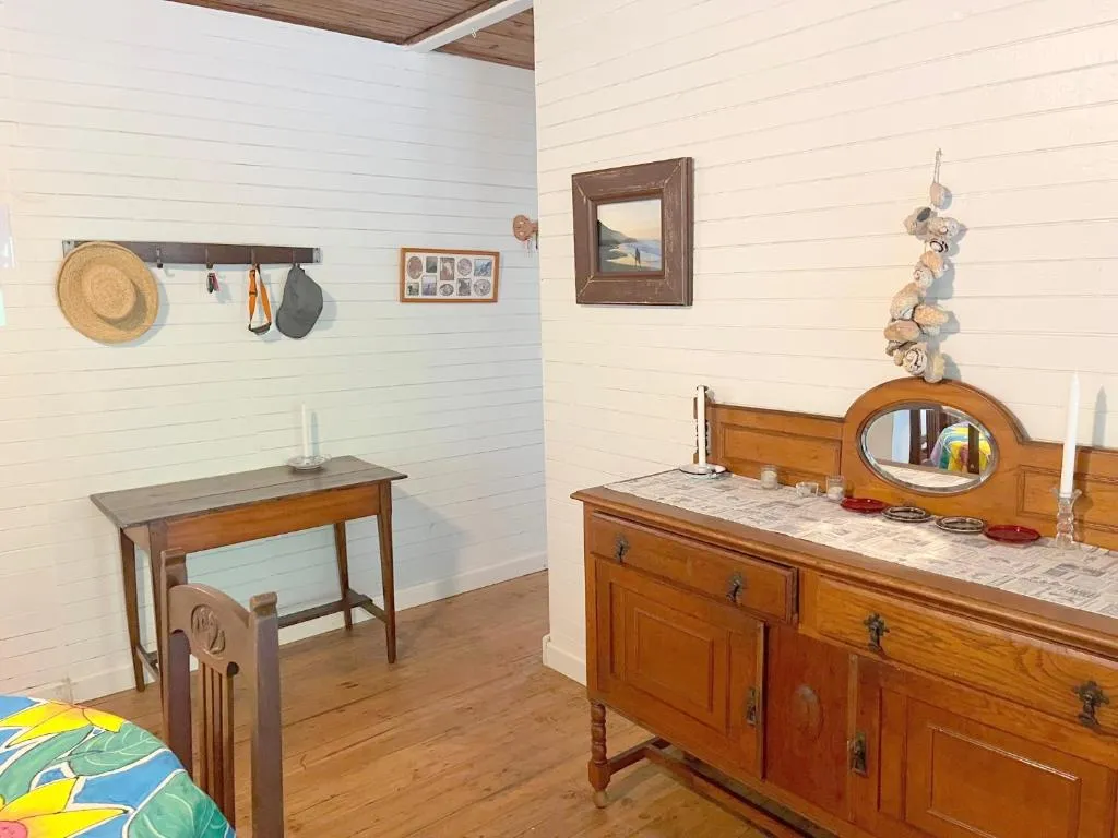 Entrance nook with a wooden hall table, sun hats and an antique sideboard