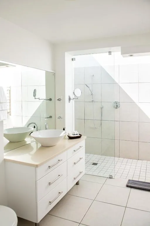 Bathroom with double vessel basins and a glass-enclosed shower