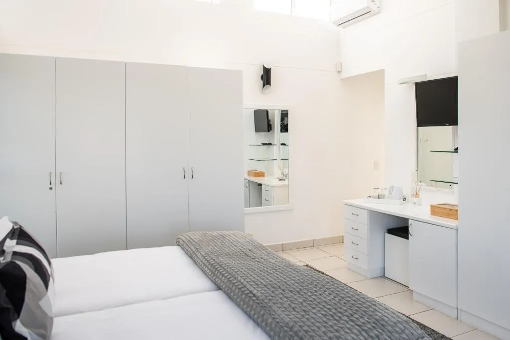 Bedroom with built-in wardrobes, a dressing area and air-conditioning unit