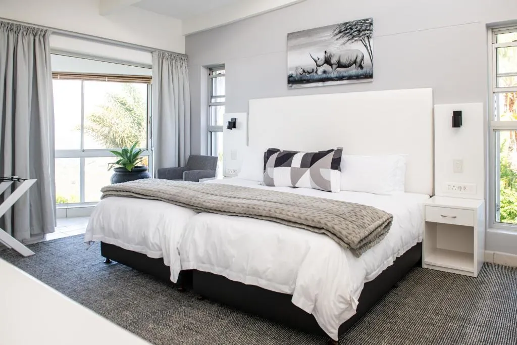 Bedroom with rhino artwork and a window looking onto garden greenery