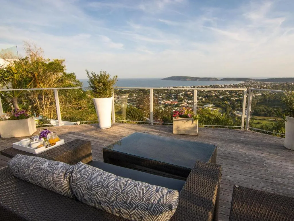 Rooftop terrace with breakfast laid out and a view over Plettenberg Bay