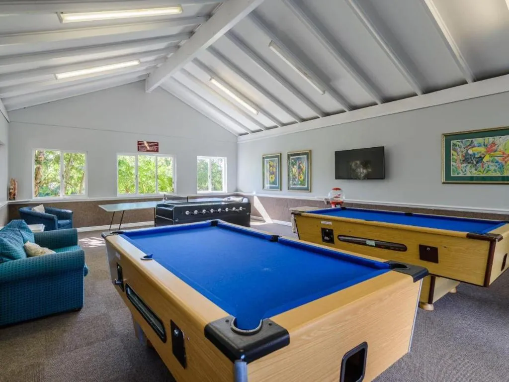 Communal games room with two pool tables, a foosball table and lounge seating