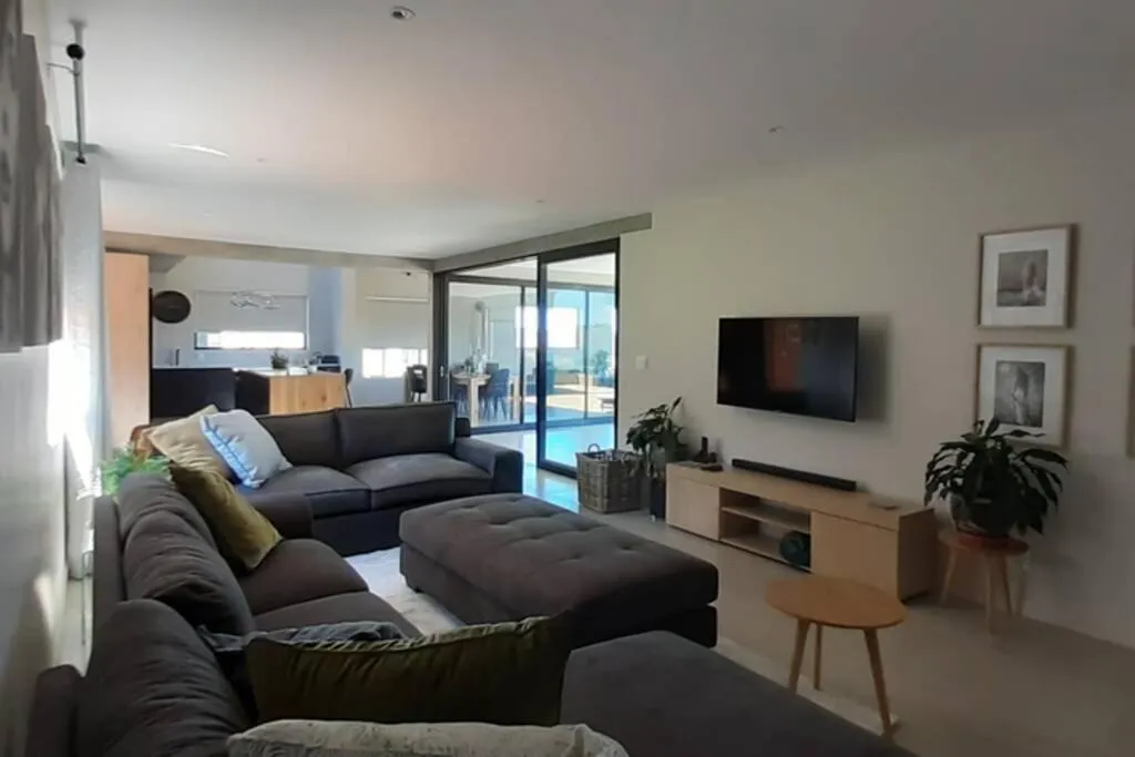 Living room with a large sectional sofa and sliding doors onto the pool terrace