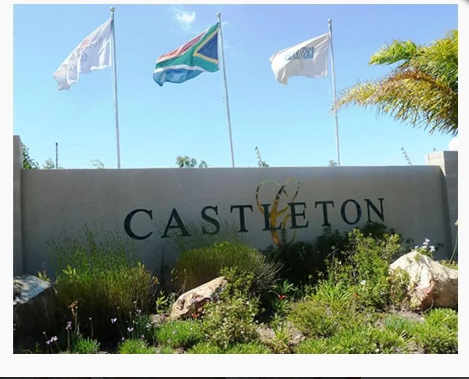 Castleton estate entrance sign framed by flagpoles and landscaped planting